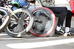 Closeup of racing bicycle in trasport. Foots in sneakers. Active lifestyle. Sun rays