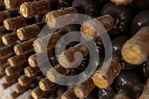 Closeup of a rack with old wine bottles covered in dust and cobweb in a winecellar in France photo