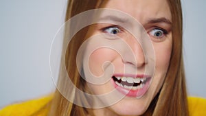 Closeup rage woman screaming at camera on grey background. Stressed female model