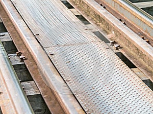 Closeup of railway train track on wooden bridge