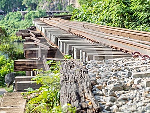 Closeup of railway train track on wooden bridge in the forest