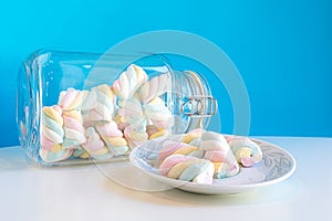 Closeup of rainbow marshmallows in a jar and in a plate
