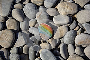 Closeup of rainbow painting on stone pebble on pebble sea beach