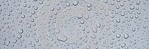 Closeup of raindrops on gray window glass texture background