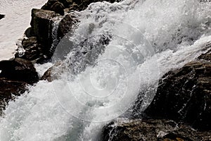 Closeup of the rapid mountain river in Susten pass located in Switzerland in winter during daylight