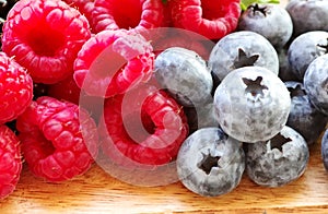 closeup of raspberries and blueberries on table