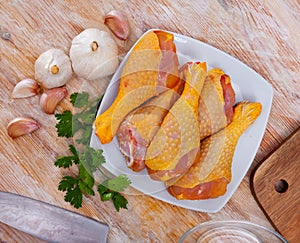 Closeup of raw chicken legs with garlic