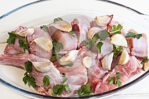 Closeup of the raw chopped chicken meat with cilantro leaf in a glass container