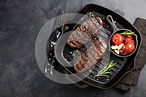 Closeup ready to eat steak Top Blade beef breeds of black Angus with grill tomato, garlic and on a wooden Board. The finished dish