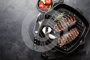 Closeup ready to eat steak Top Blade beef breeds of black Angus with grill tomato, garlic and on a wooden Board. The finished dish