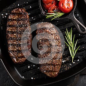 Closeup ready to eat steak Top Blade beef breeds of black Angus with grill tomato, garlic and on a wooden Board. The finished dish