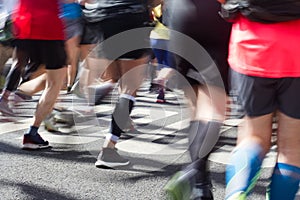 Closeup rear view on marathon runners legs and feet with motion