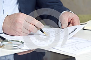 Closeup of recruiter`s hands holding resume to approve one. Concept of searching employees photo