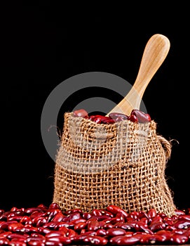 Closeup red beans or kidney bean in wooden bowl isolated on wood table background