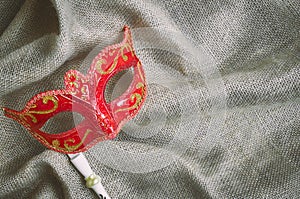 Closeup red carnival mask, venetian mask place on the burlap sackcloth, Top view