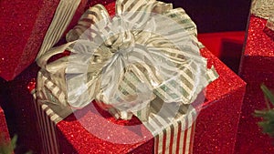 Closeup Red Christmas present with gold bow and ribbons.