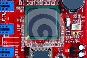 Closeup of red electronic motherboard circuit with processor