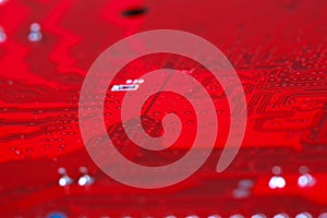 Closeup of red electronic motherboard circuit with processor