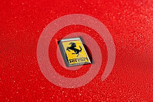 a ferrari badge on a red sports car closeup on its hood