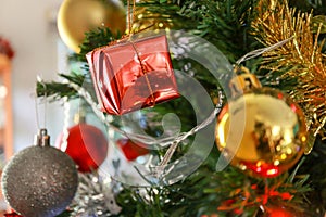 Closeup Red Gift Box on Christmas Tree Background. Merry christmas and Happy New Year concept