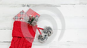 Closeup of red knit Christmas stocking on white wood background photo