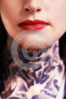 Closeup, red lipstick and woman with tattoos, makeup and culture with rebel and confident. Person, mouth and product