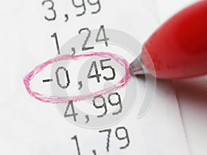 Closeup red pen encircle negative number on bill or receipt photo