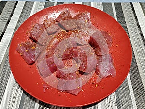 Closeup of a red plate with raw cut tuna.