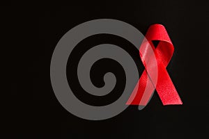 Closeup red ribbon awareness on black background for World Aids day