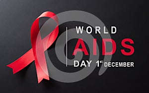 Closeup red ribbon HIV, world AIDS day awareness ribbon on black background. Healthcare and medicine concept