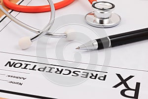 Closeup of red stethoscope and pen on a rx prescription.