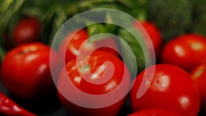 Closeup red tomatos with green leaves in basket. Close-up delicious organic healthful nutritious food ingredients with