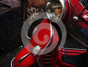 Closeup of a red Vespa motor scooter on the street
