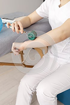 Closeup Rehabilitation Specialist, Physical Therapist Shows Rehab Tool Meso Roller With photo