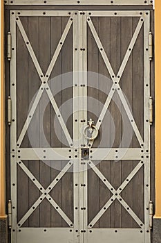 Closeup Of Reinforced Double Leaf Wooden Door With Iron Element