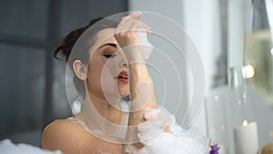 Closeup relaxed sensual washing hands in bathtub. Cute woman relaxing in bath.