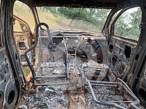 Closeup of the remains of an old crashed car burned from the inside