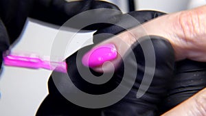 Closeup of removing nail cuticles and fingernail polishing using electric manicure drill machine.