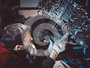 Closeup repair of an opposing engine by an auto mechanic.