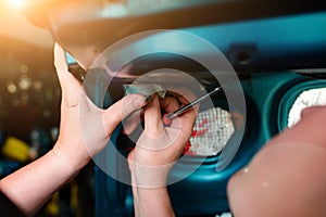 Closeup repairing of an broken blue car in garage by hands of machanic