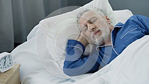 Closeup of retired man sleeping in bed in the morning, recovery time, health