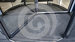 Closeup of revolving doors rotating in the entrance of modern business center or shopping mall