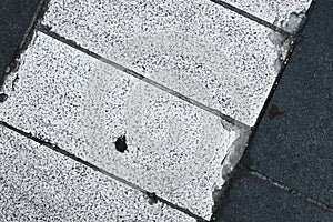 Closeup of road texture and pattern, textured street ground surface, white and dark lines of crossing in the city, grunge pavement