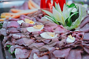 Closeup of roast beef slices with hard-boiled eggs on a tray in a restaurant
