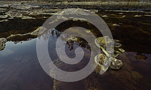 Closeup of rocks in red acidic and polluted Rio Tinto River due to mining, in Spain