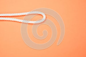 Closeup of a rope noose isolated on a vibrant peach-colored background