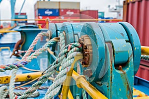 closeup of ropes and winches securing containers on deck during transit