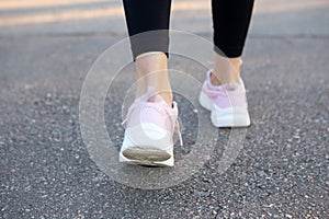 Closeup on running shoes of woman on the running road.