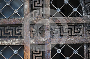 Closeup of a rusty metallic door with spider webs on it in an old graveyard