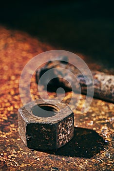 Rusty nut and bolt on a rusty surface